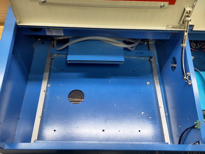 Blått hölje av en Kina-laser, med öppet lock och aluminiumskenor installerade för att stabilisera botten.