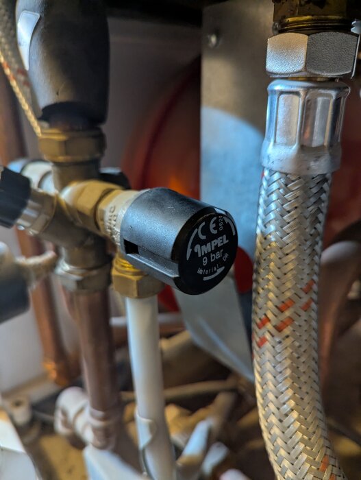 Säkerhetsventil bytt på varmvattenberedare. Närbild visar anslutningar och ventil med texten "IMPEL 9 bar".