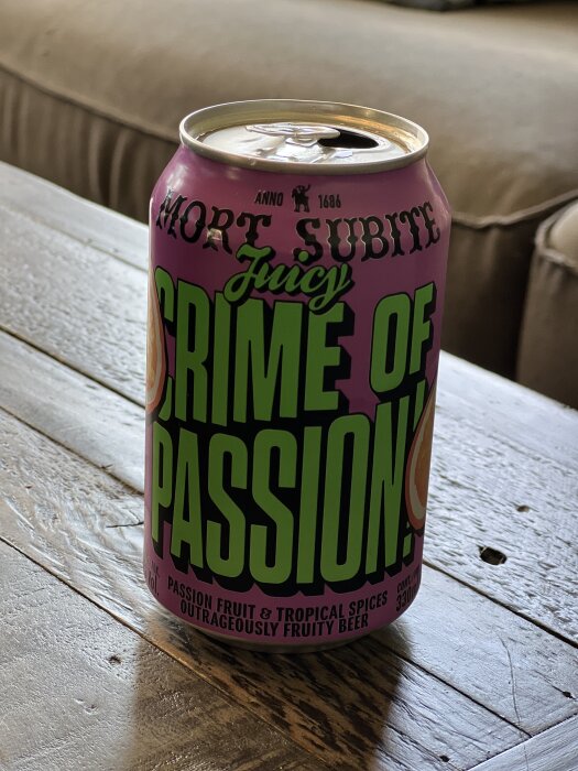 En ölburk med etiketten "Mort Subite Juicy Crime of Passion" på ett träbord.