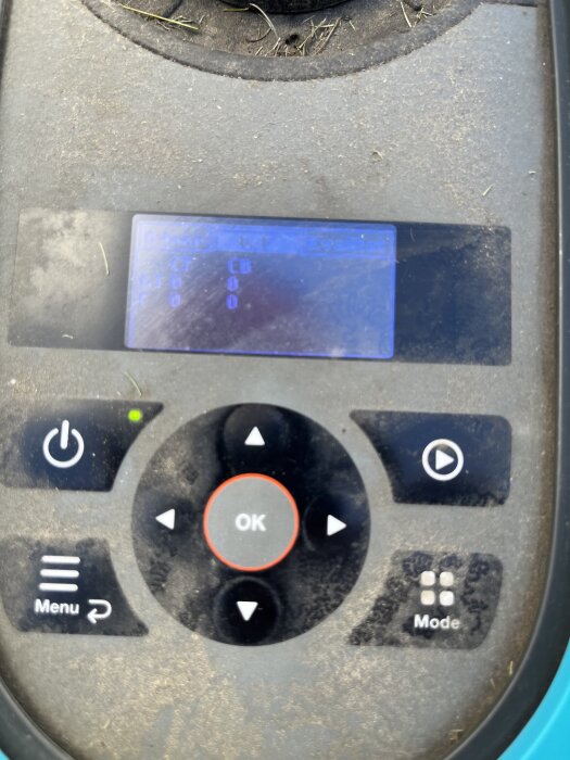 Display på robotgräsklippare visar siffror, med kontrollpanel och knappar runt, grön lampa lyser.