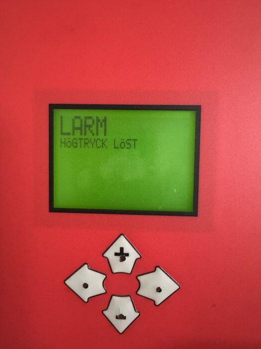 Display på värmepump med texten "Larm, högtryck löst" och navigeringsknappar syns.