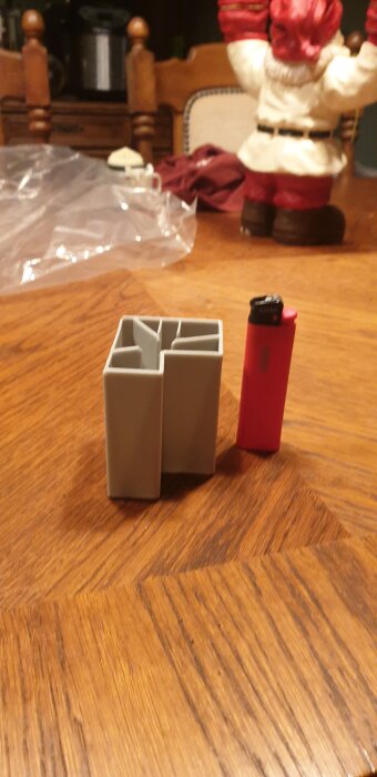 Diskmaskinsdel och tändare på ett bord med en tomtefigur i bakgrunden.