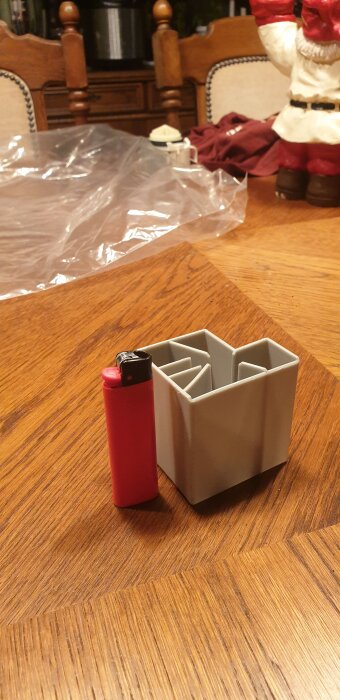 Plastdel från diskmaskin på träbord bredvid tändare.