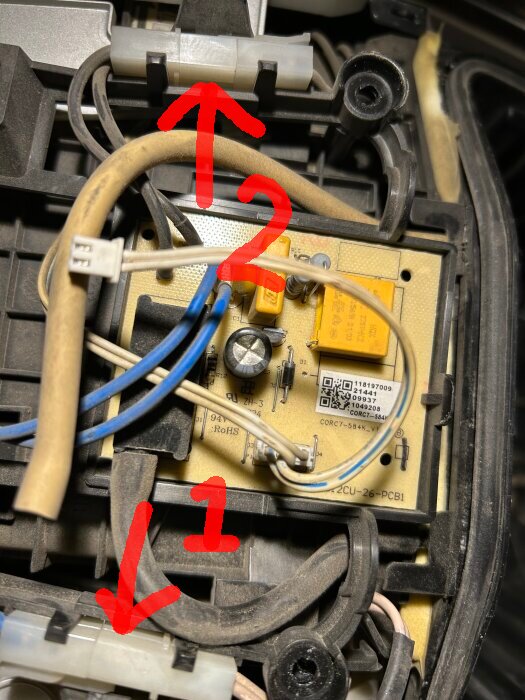 Kretskort med markerade anslutningar 1 och 2 och flera anslutna kablar i en teknisk installation.