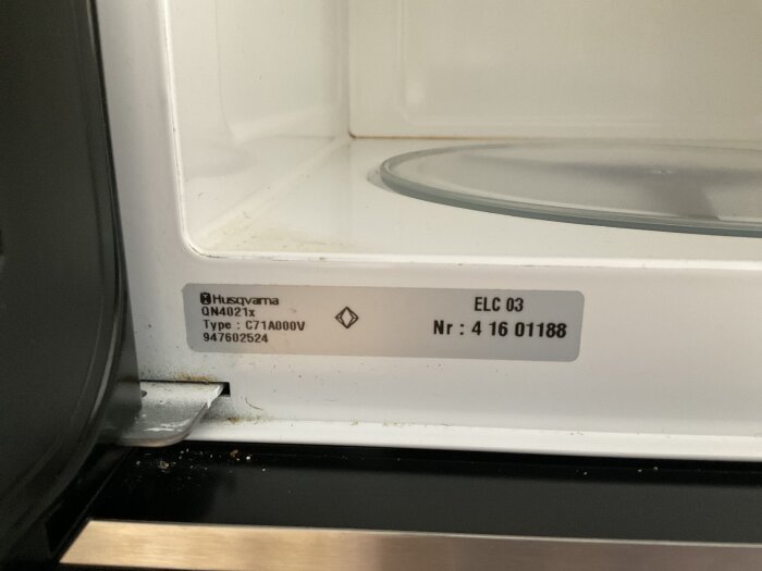 Husqvarna mikrovågsugn med modellnumret QN4021x och typen C71A0000V, visas inuti med identifieringsetikett.