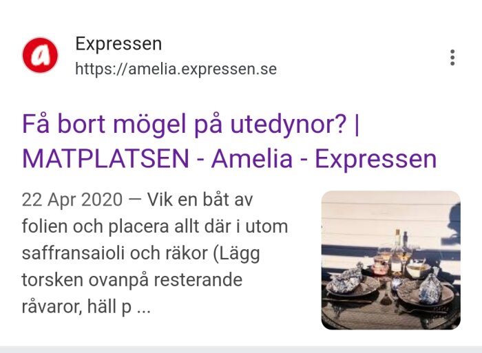Uteplats med bord, dukat med tallrikar och folieförpackningar, i solen framför en ljus vägg.