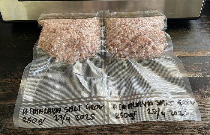 Vakuumförpackade påsar med grovt rosa himalayasalt, etiketterade som 500g och 2x250g, för varaktig lagring.