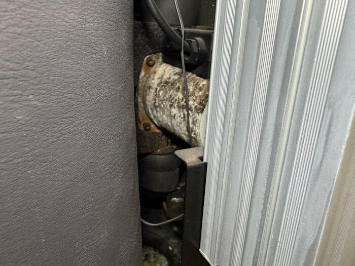 Närbild av en gammal, rostig komponent på en IVT Greenline C7 bergvärmepump med tecken på korrosion och fukt.