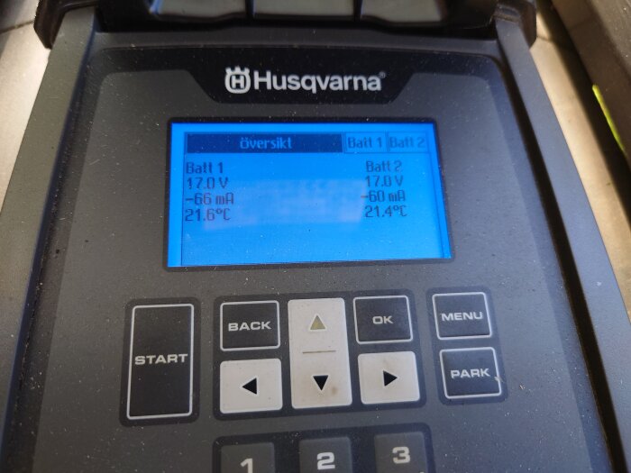 Husqvarna display som visar batteristatus för Batteri 1 och Batteri 2 med spänning, strömstyrka och temperatur.