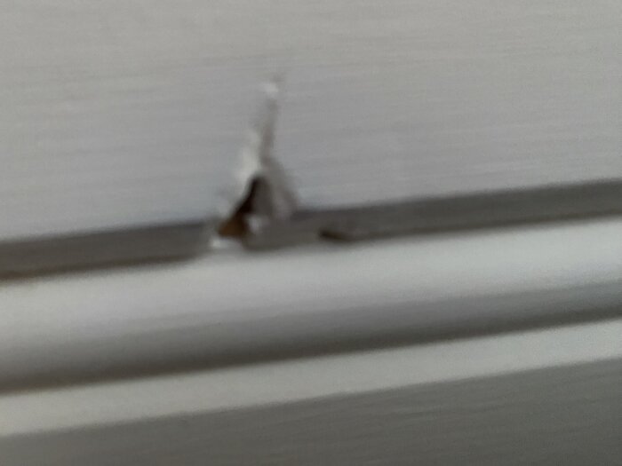 Bild av hål i taket på ett hus byggt 2010, med skador runt hålets kanter.