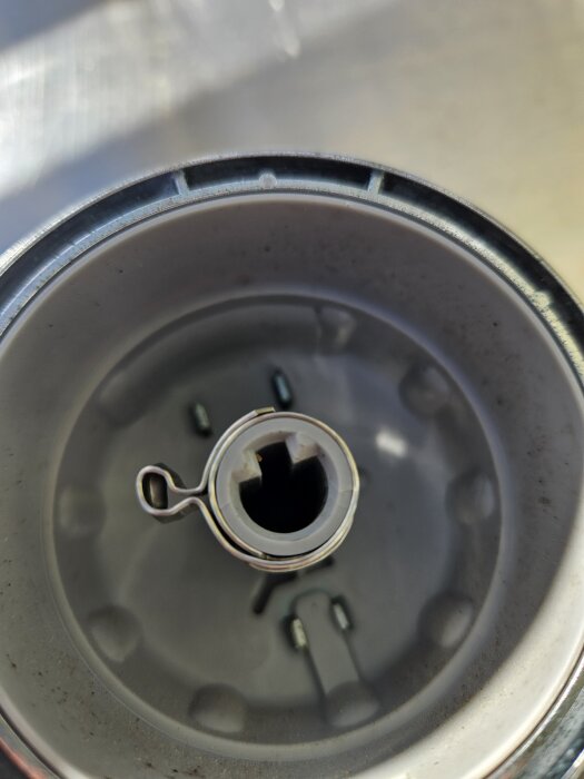 Närbild på gasreglage på en Webergrill med en rostfri slangklämma som förstärkning av infästningen vid sprickbildning.