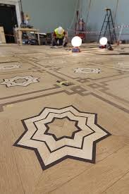 Nyrenoverat parkettgolv i Nationalmuseum med detaljrika stjärnmönster och pågående arbete i bakgrunden.