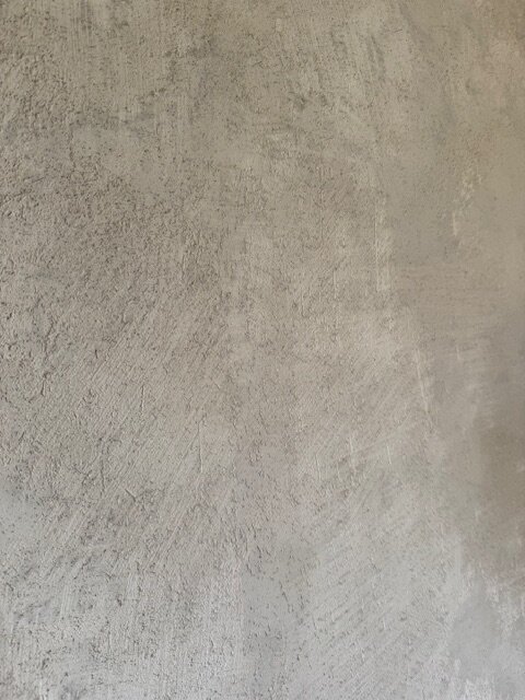 Skrovlig vägg med ojämn gipsputs, resultat av misslyckad renovering. Ytan är avsedd att vara sidenmatt och slät men uppvisar spår av ballasten.