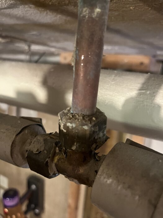 Rostiga rörkopplingar under ett handfat, med två olika rörstorlekar; ett 15mm och ett 16mm. Kopplingarna är slitna och behöver proppas.