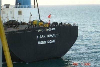 Stort fraktfartyg med namnet "Titan Uranus" och registreringsnummer synligt på aktern, registrerat i Hong Kong, i havsmiljö.