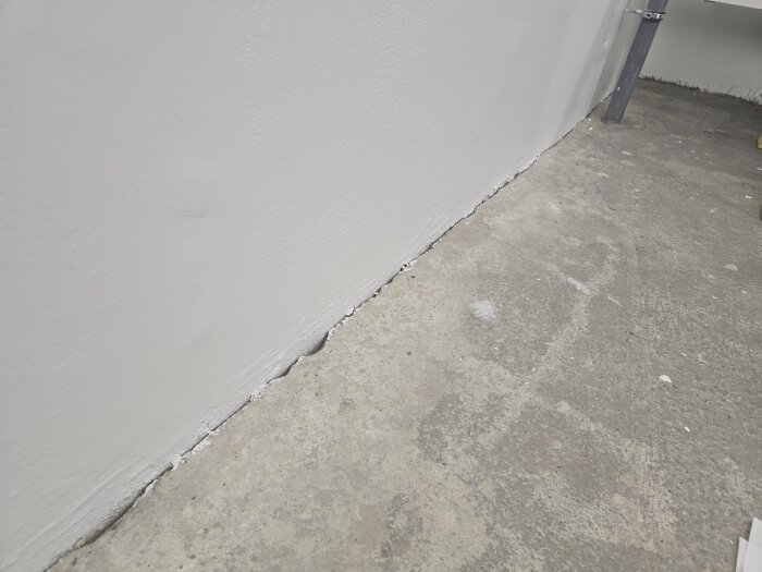 Spricka mellan betonggolv och vägg; visar glipa som ska tätas med limfog för att förhindra krypning av skadedjur som silverfisk.
