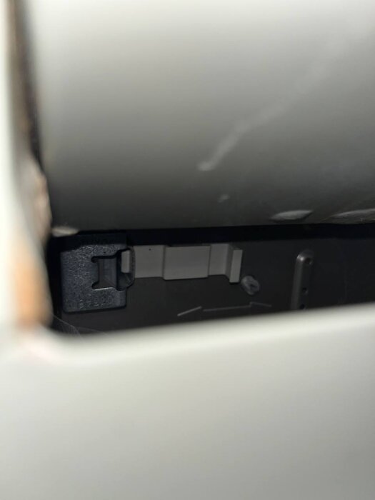 Inuti ett skåp bredvid en diskmaskin, där en öppen sektion med några synliga delar och kablar kan ses. Eventuellt problem med ångläckage.