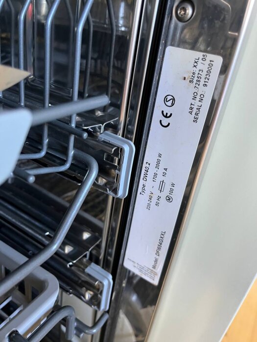 ASKO-diskmaskin interiör med etikett som visar specifikationer för modell DFI654GXXL och serienummer 91230001.