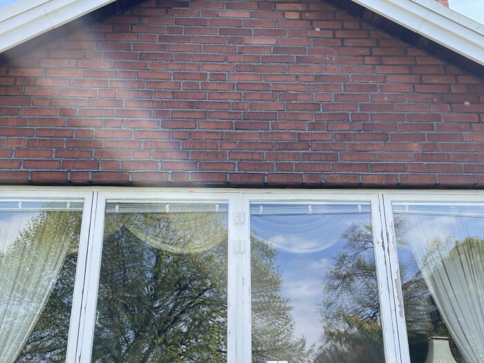 Tegelvägg ovanför ett fönsterparti med gardiner; diskussion om att använda Murma väggbalksystem för att modifiera tegel över fönstret.