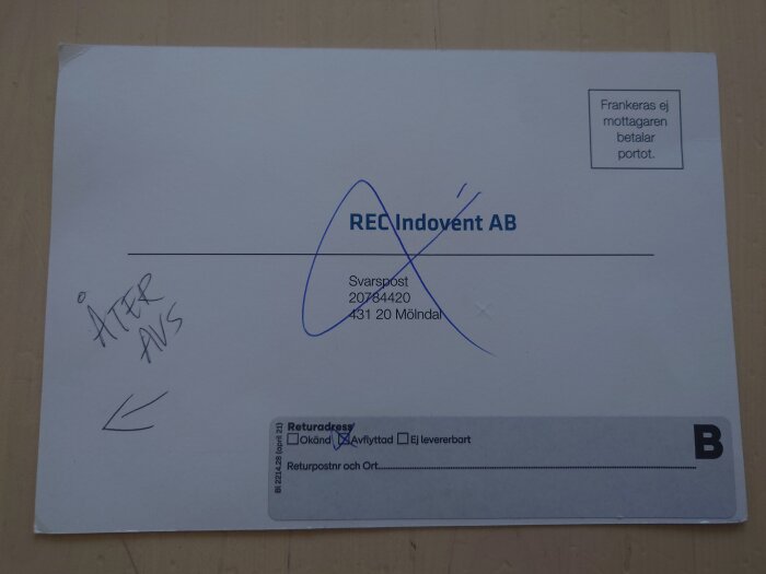 Återvänd försändelse från REC Indovent AB, med "Åter avs" och en överstruken adress, på ett bord.