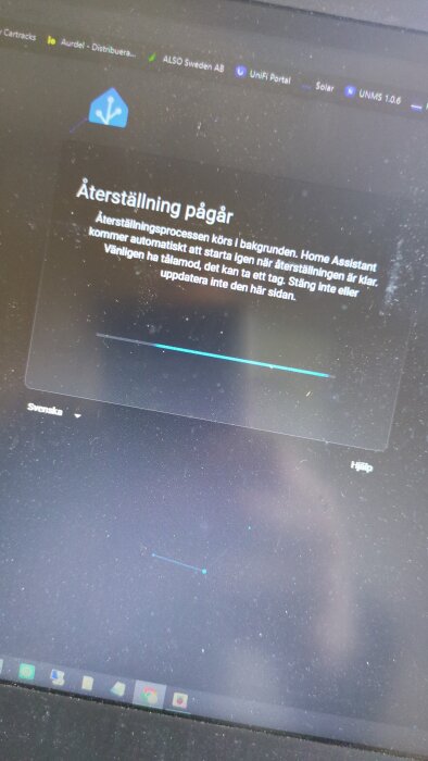 Bild på en datorskärm som visar en pågående återställning av Home Assistant, med text om att processen körs i bakgrunden.
