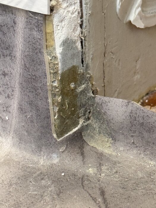 Våtrumsmatta vid dörröppning. Mattan är skuren i hörnen och silikon finns över skärsnitten. Diskussion om korrekt installation.