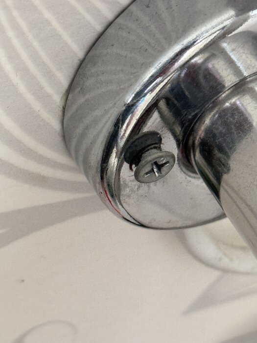 Handdukstork monterad med felaktig skruv och bricka, visar bristande hantverksskicklighet.