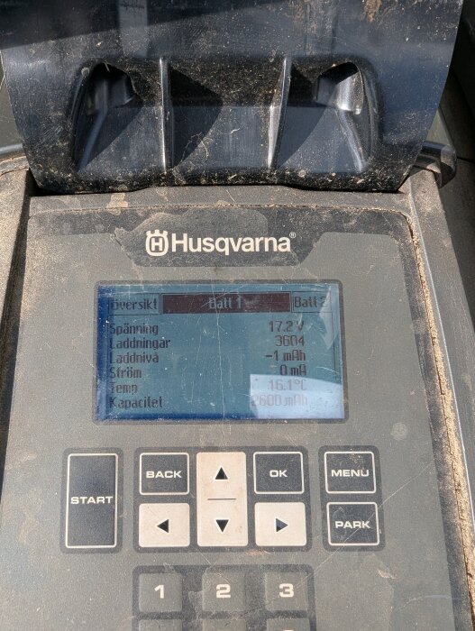 Bild av en smutsig Husqvarna-batteridisplay med mätvärden för spänning, laddningar, laddnivå, ström, temperatur och kapacitet.
