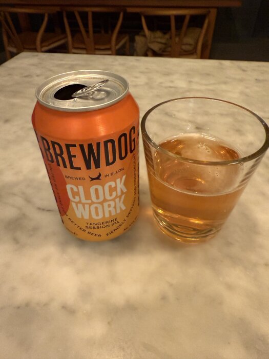 Ölburk och glas på ett bord, märket Brewdog Clockwork Tangerine Session IPA.