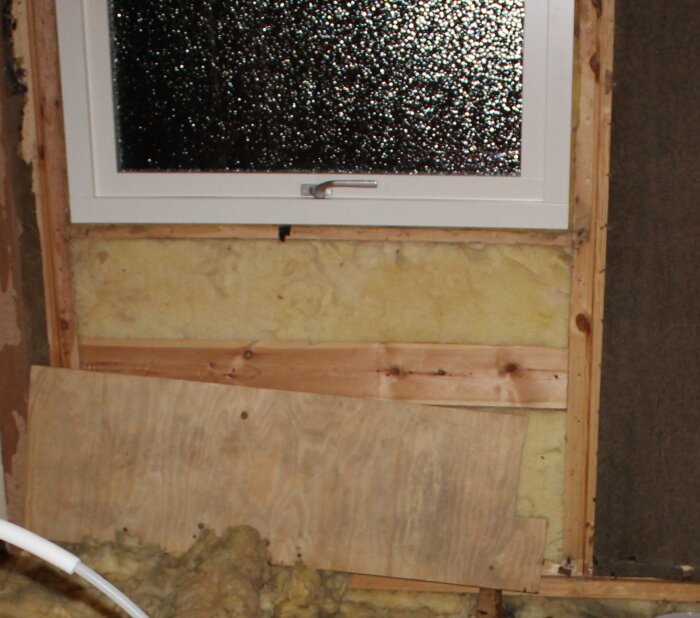 Badrumsrenovering med träplankor, isolering och ett fönster. Plankan är 1,5-2 cm tjock och 10-12 cm hög.