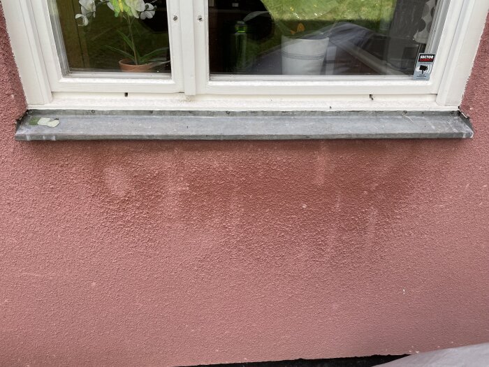 Fönsterbleck med färgrester på fasad, rosa puts. Planerar att rengöra och fräscha upp för att få renare yta utan blank finish.