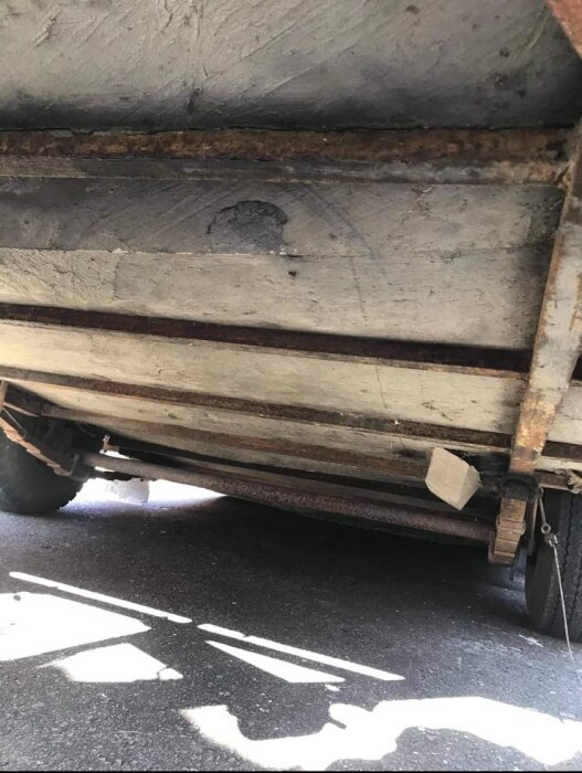 Undersidan av en gammal SMV10 husvagn i dåligt skick, med rostiga och slitna delar.