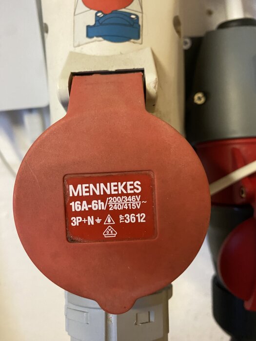 Rött 3-fasuttag från Mennekes med text 16A-6h/200-346V/240-415V, 3P+N, i en verkstadsmiljö.