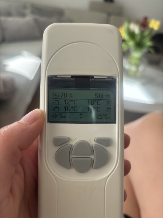 Fjärrkontroll med display visar temperaturer: 12°C, 16°C, 18°C, fuktighet 70%, symboler och plusikon i hörnet.