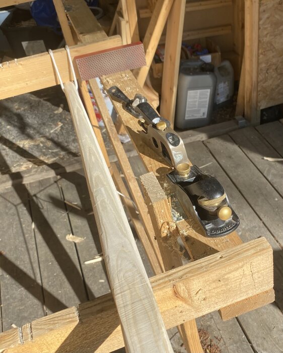 En improviserad täljhäst i trä med en långbågeämne fastsatt, omgiven av verktyg som en hyvel och filer för bearbetning.
