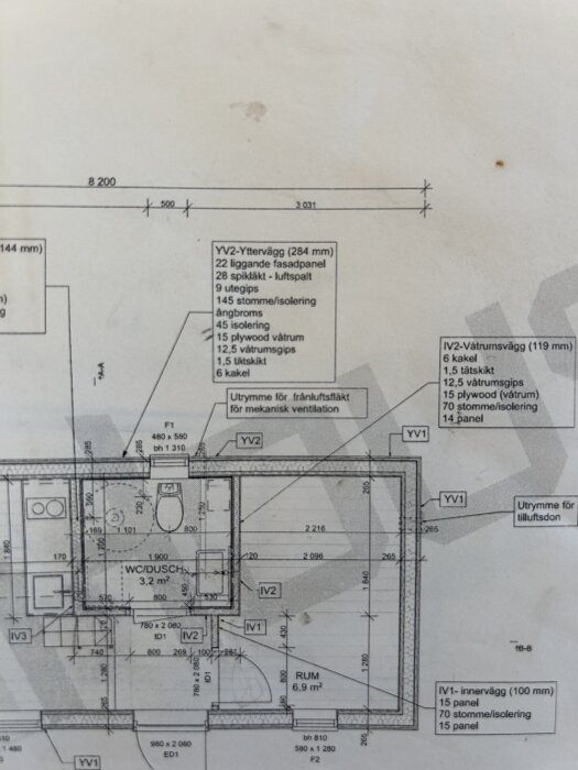 Ritning av yttervägg mot badrum med ångbroms och tätskikt. Inkluderar specifikationer av materiallager som fasadpanel, isolering och kakel.