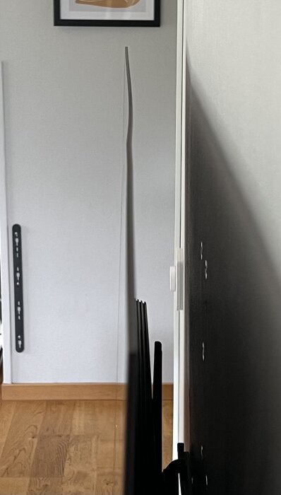 Sidovy av en smal Samsung 55” TV som visar en lätt böjning i överkanten mot en ljus bakgrund.