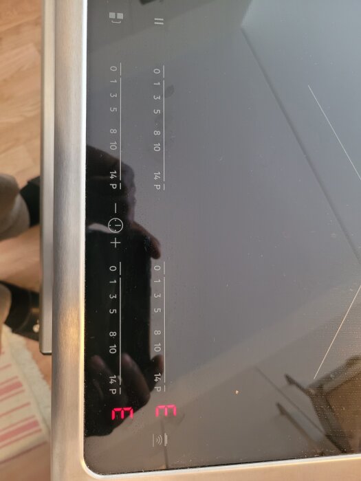 Elektronisk kontrollpanel på en induktionshäll från Electrolux med lysande röda siffror på de två högra zonerna.