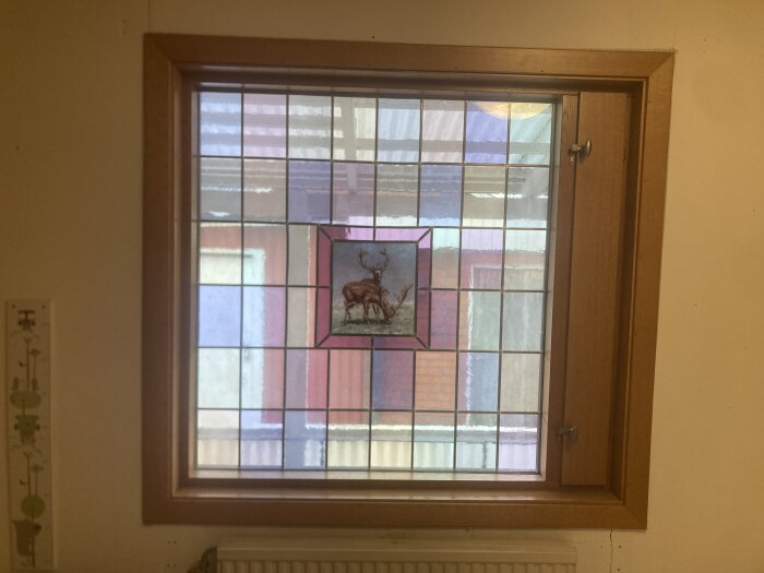Blyinfattad glasskiva med kronhjortsmotiv, färgade rutor och träram. Passar som fönster eller konstverk. Finns i Halmstad, 1000 kr.