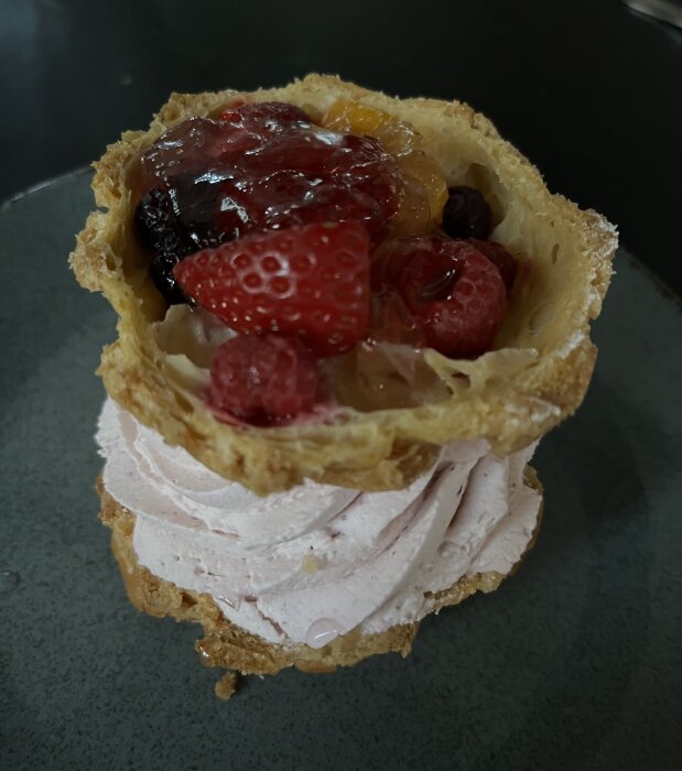 Bakelse med grädde, färska bär och sylt på ett fat.