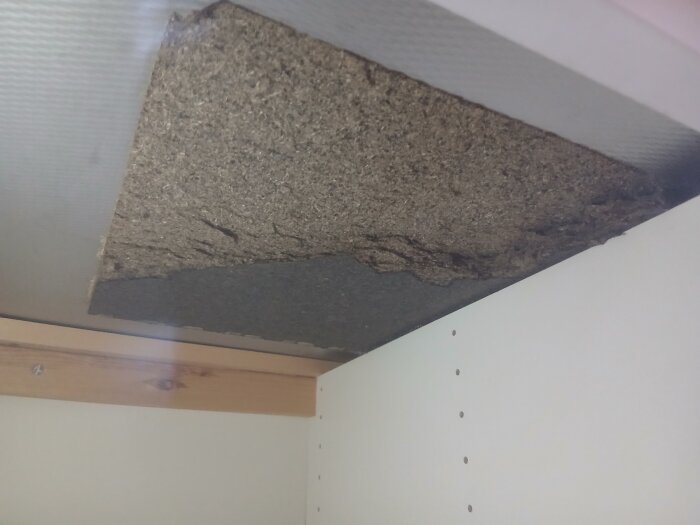 Filtliknande material med svarta fläckar mellan diskbänken och skåpsnickeri, åldrat och med möjligtvis unken lukt, potentiellt från 1959.