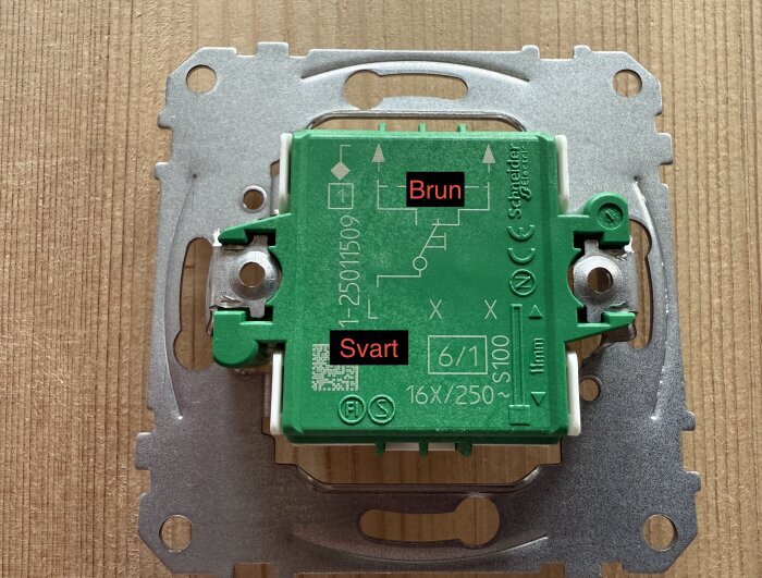 Strömställarbakstycke med text som visar var bruna och svarta ledningar ska placeras.