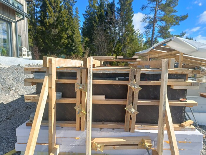 Byggarbetsplats med träform och stabilisering. Kantarbete förbereds med viktning för att klara av 1000 kg på varje sida i en skogsmiljö.