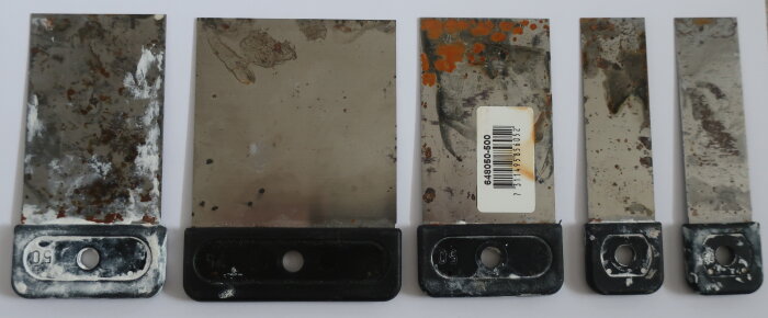 Fem japanspacklar av varierande storlek med rostfläckar, placerade på vitt underlag.