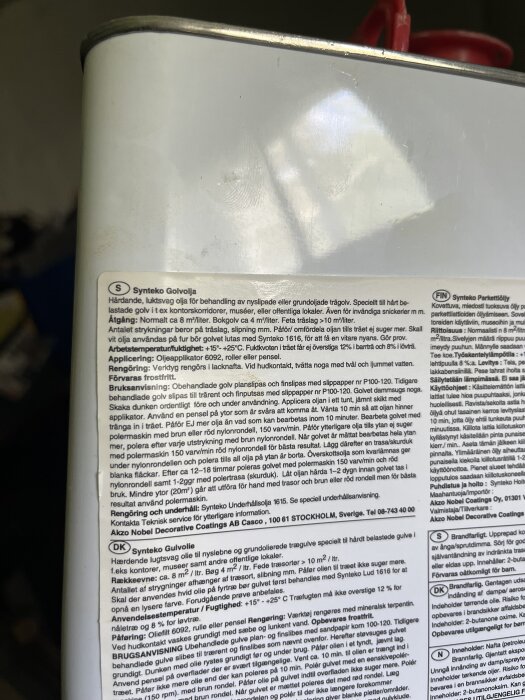 Bild på en burk med Synteko golvolja, inklusive detaljerad produktinformation och instruktioner för användning av oljan på trä- och parkettgolv.