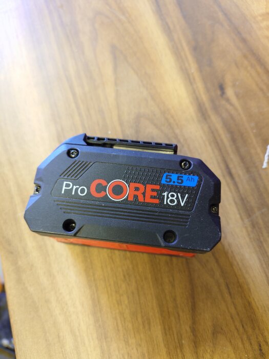 Batteri ProCORE 18V 5.5 Ah liggande på ett träbord.