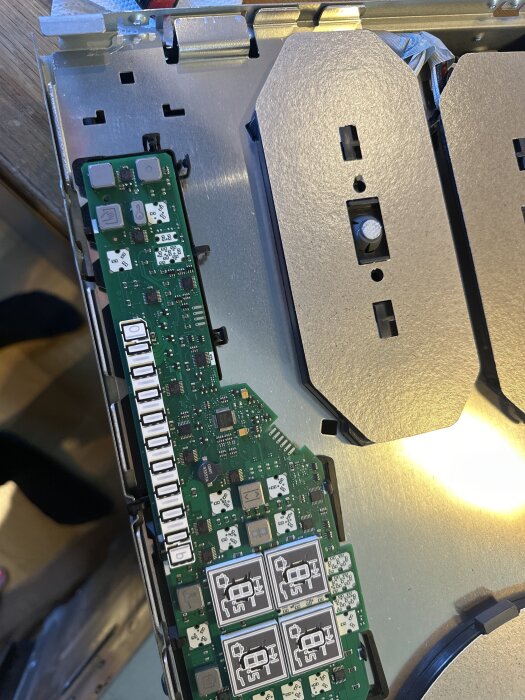 Närbild av ett kretskort från en Siemens induktionshäll, avtäckt med synliga komponenter och kontaktpunkter.