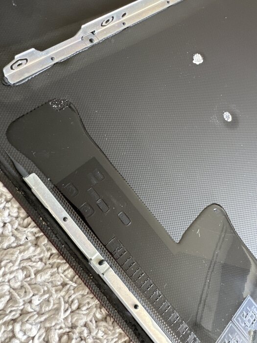 Närbild på undersidan av en Siemens induktionshäll från 2017 där kontrollpanelen och metallkomponenter syns.