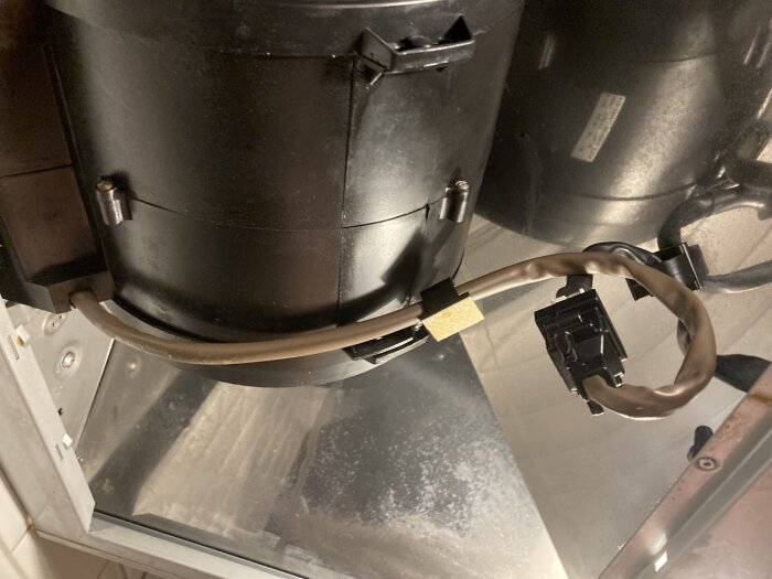 Insidan av en Gorenje kolfilterfläkt från 2008 med vridna kablar och fläktdelar synliga.