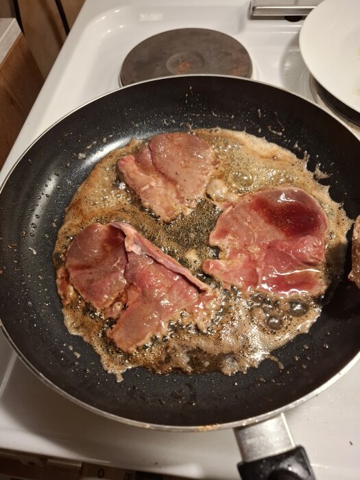Stekning av lövbiff i en stekpanna på spisen.